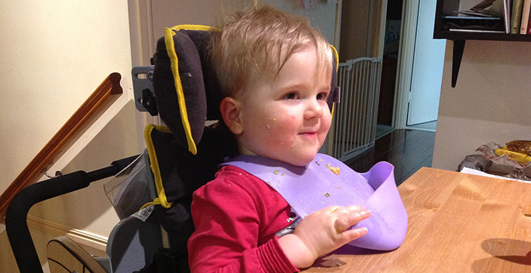 A young girl sitting in her Jenx Bee chair eating dinner