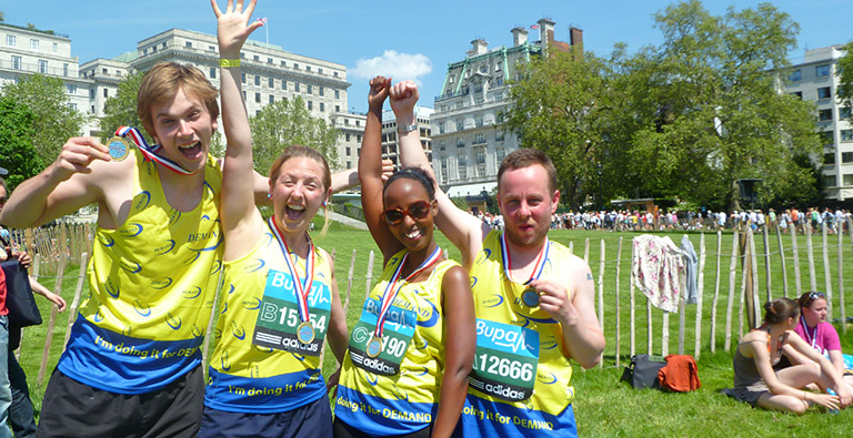 Four fundraisers celebrate finishing a race